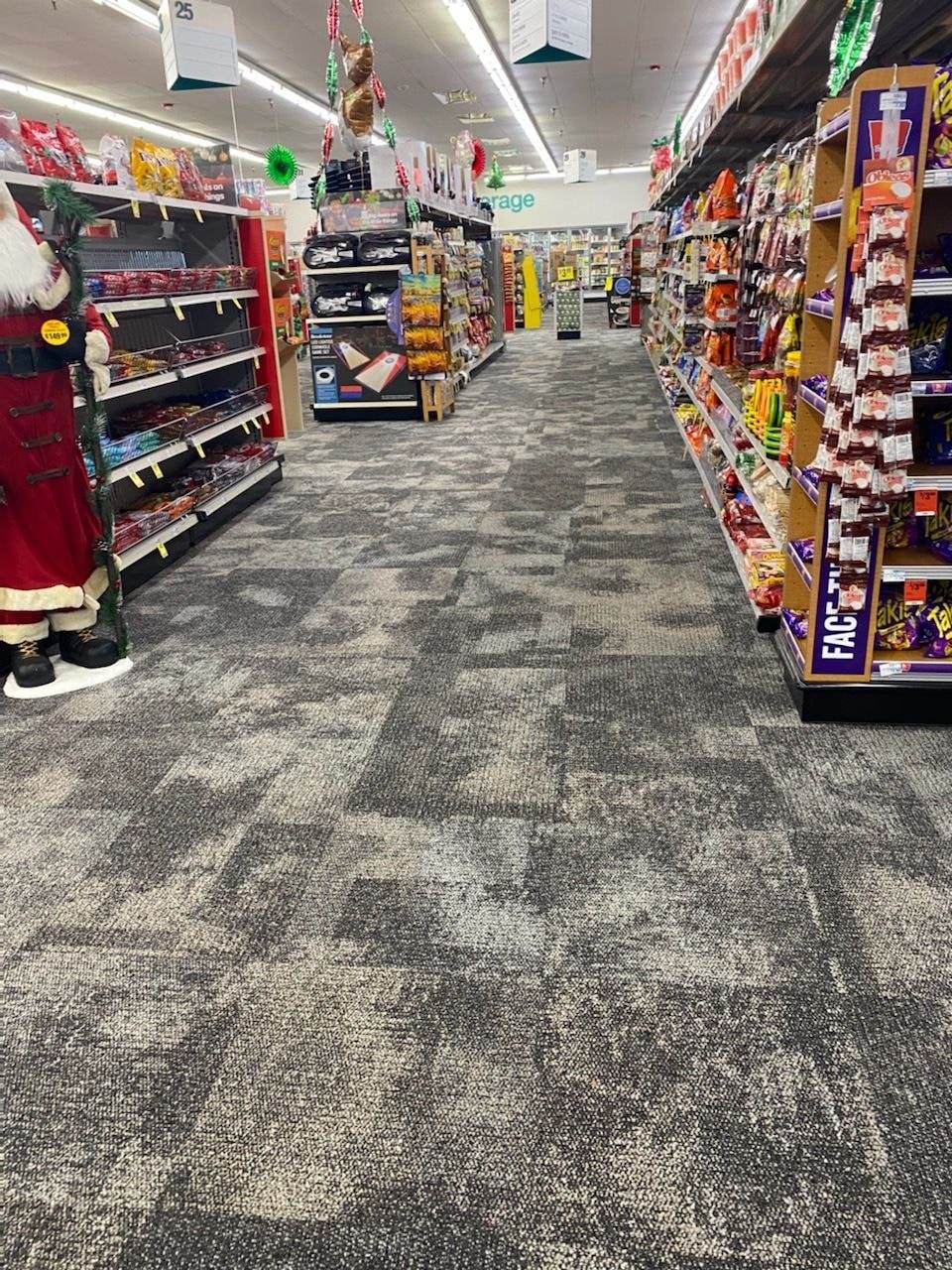 Pasillo de una tienda con piso de losetas de alfombra gris